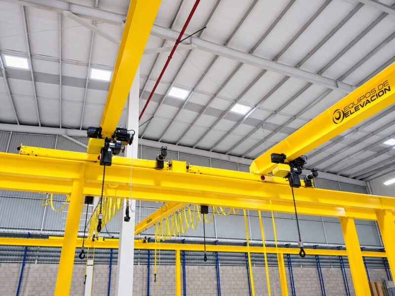 Puente grúa amarillo en fábrica luminosa